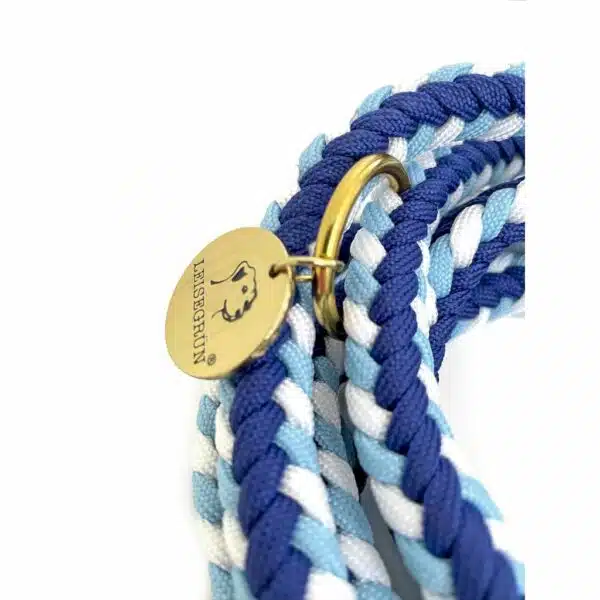 Nahaufnahme der Paracord-Leine in Hellblau, Blau und Weiß mit goldenem Leisegrün-Emblem.